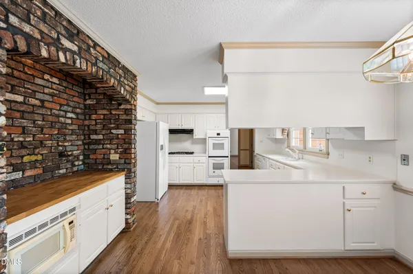 a kitchen with granite countertop white cabinets and white appliances