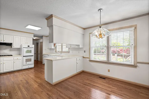 a view of a kitchen with a sink wooden floor and windows