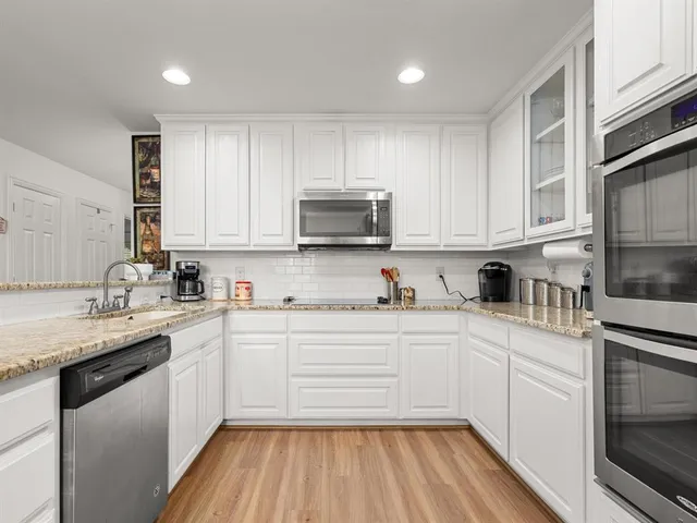 a kitchen with granite countertop white cabinets and white appliances