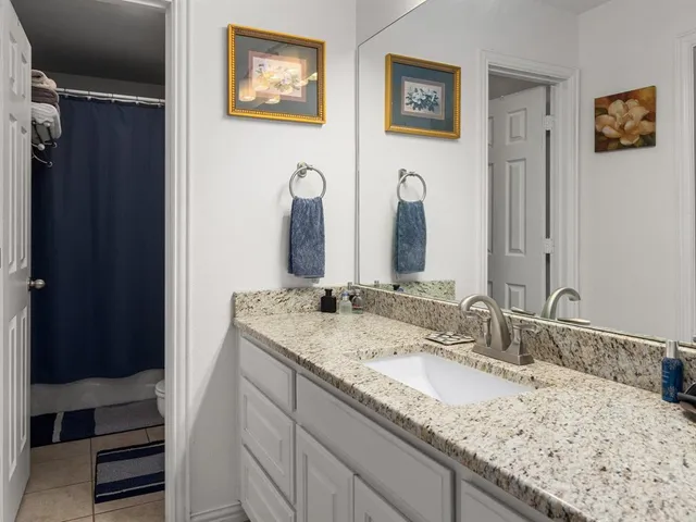 a bathroom with a granite countertop double vanity sink and a mirror