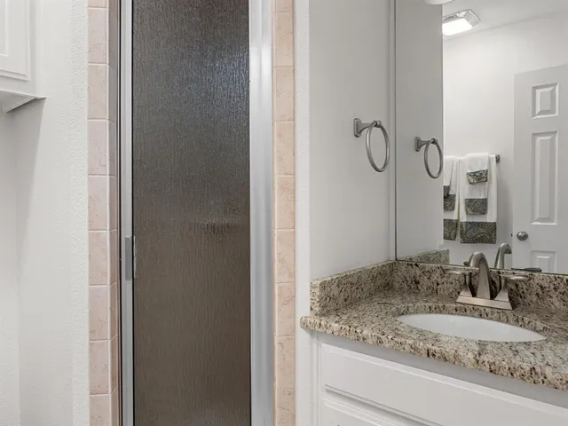 a bathroom with a granite countertop sink and a mirror