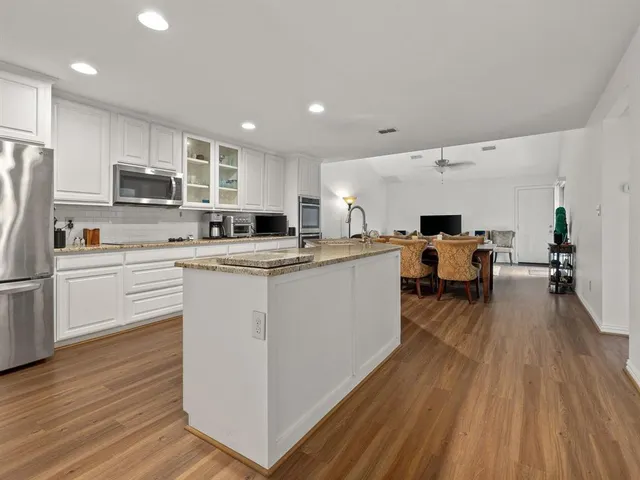 a kitchen with a sink a counter top space stainless steel appliances and cabinets