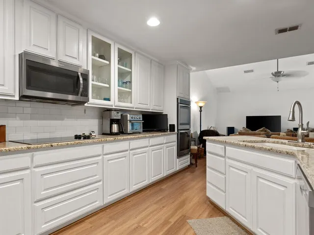 a kitchen with stainless steel appliances granite countertop a stove and a microwave