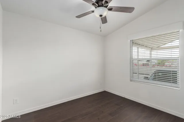 an empty room with a window and a fan