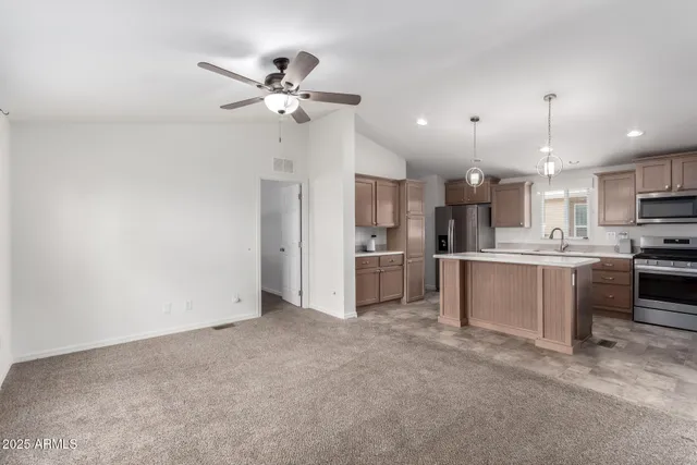 a view of kitchen with refrigerator and white cabinets