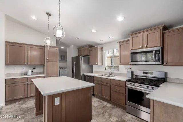a kitchen with stainless steel appliances a stove sink microwave and cabinets