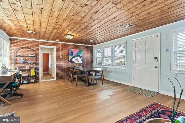 a dining room with wooden floor furniture and a chandelier