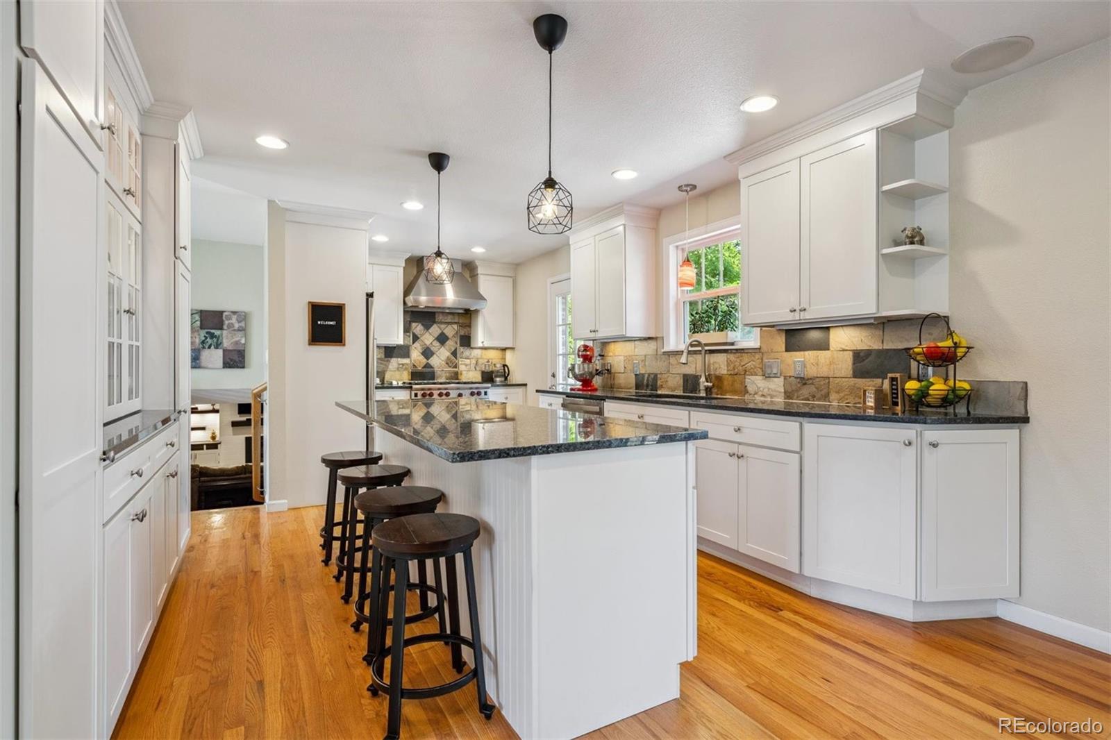 7659 South Fillmore Way Centennial, CO 80122 - Photo 11 of 45 a kitchen with stainless steel appliances kitchen island a refrigerator and a stove top oven