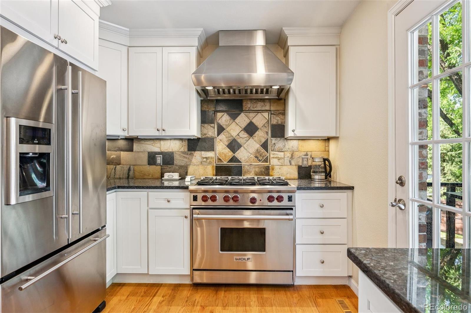 7659 South Fillmore Way Centennial, CO 80122 - Photo 14 of 45 a kitchen with stainless steel appliances granite countertop a stove and a refrigerator