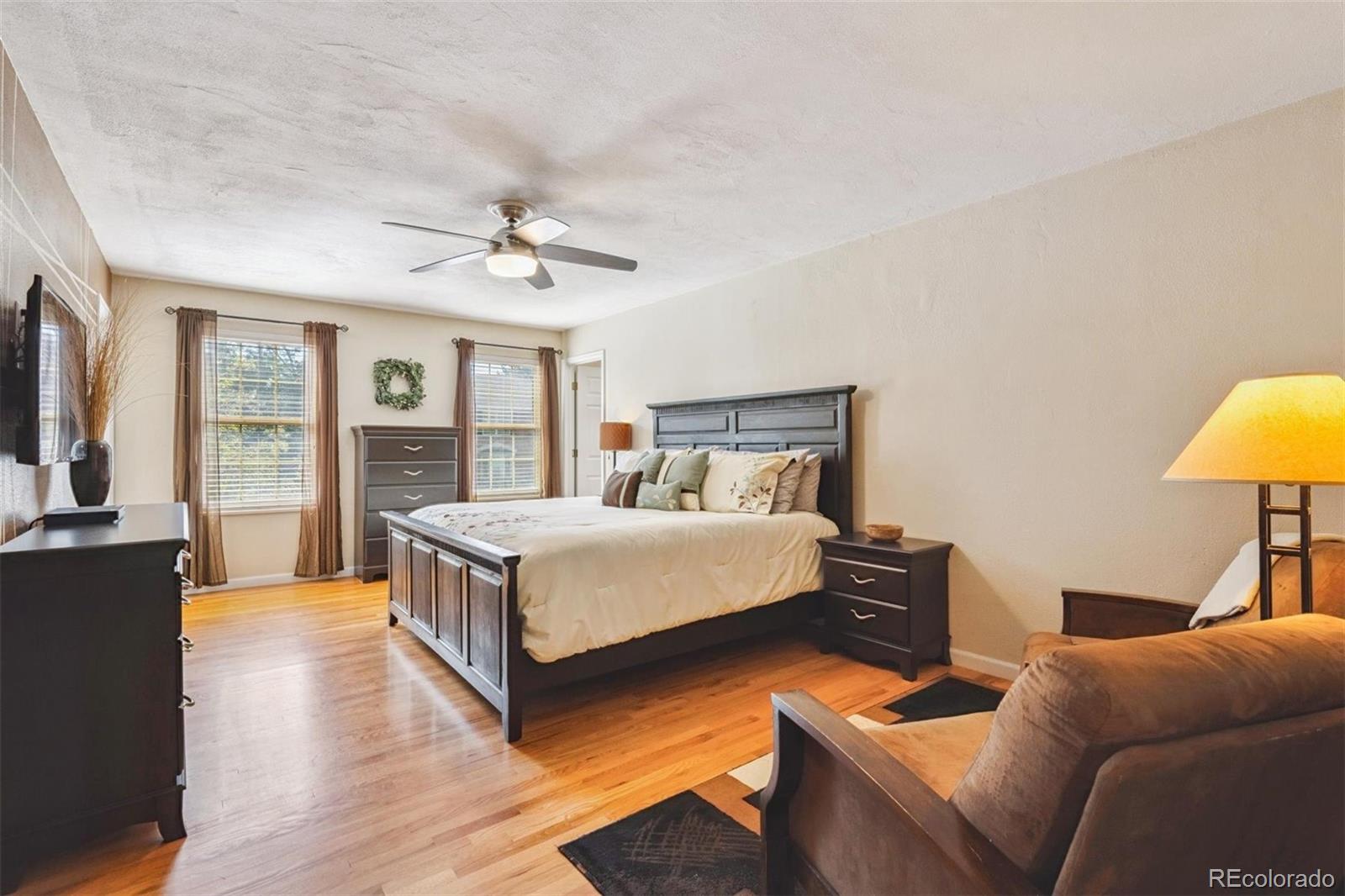 7659 South Fillmore Way Centennial, CO 80122 - Photo 17 of 45 a bedroom with a bed couch and a chandelier