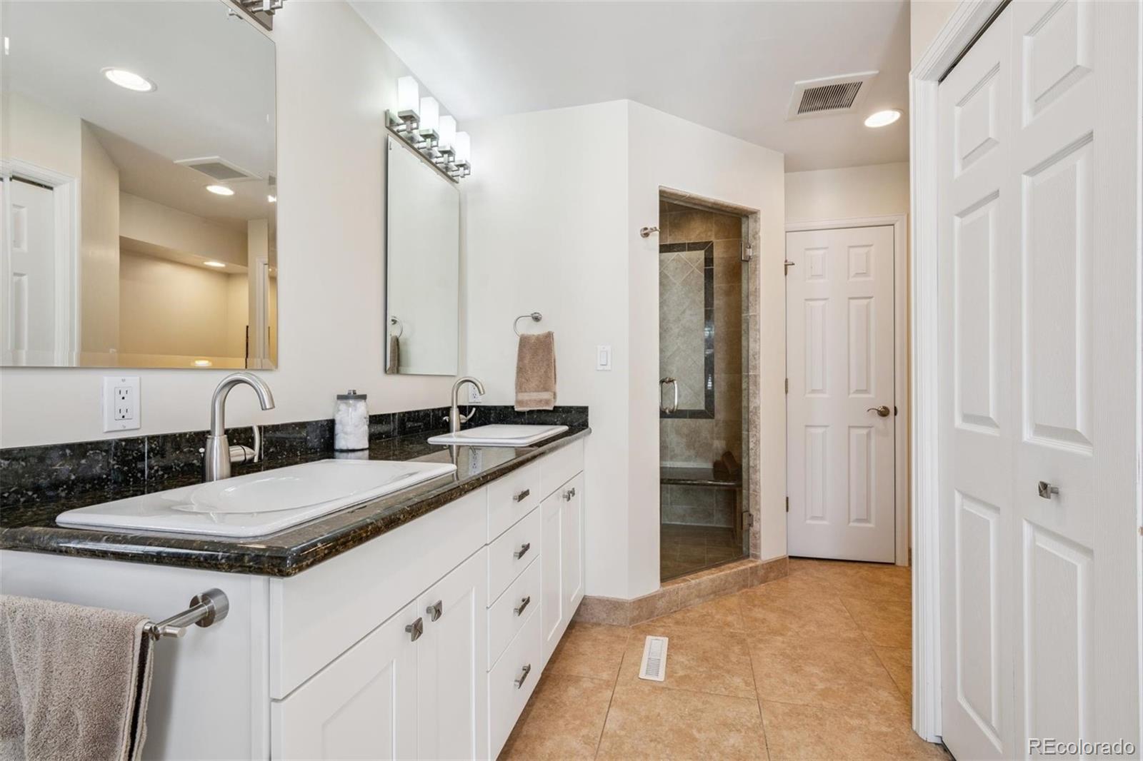 7659 South Fillmore Way Centennial, CO 80122 - Photo 19 of 45 a spacious bathroom with a granite countertop sink and a mirror