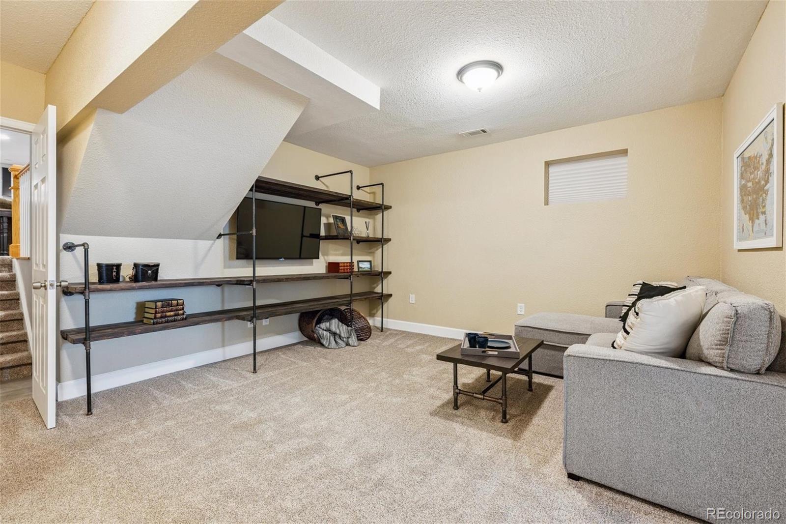 7659 South Fillmore Way Centennial, CO 80122 - Photo 29 of 45 a living room with furniture and a wall painting
