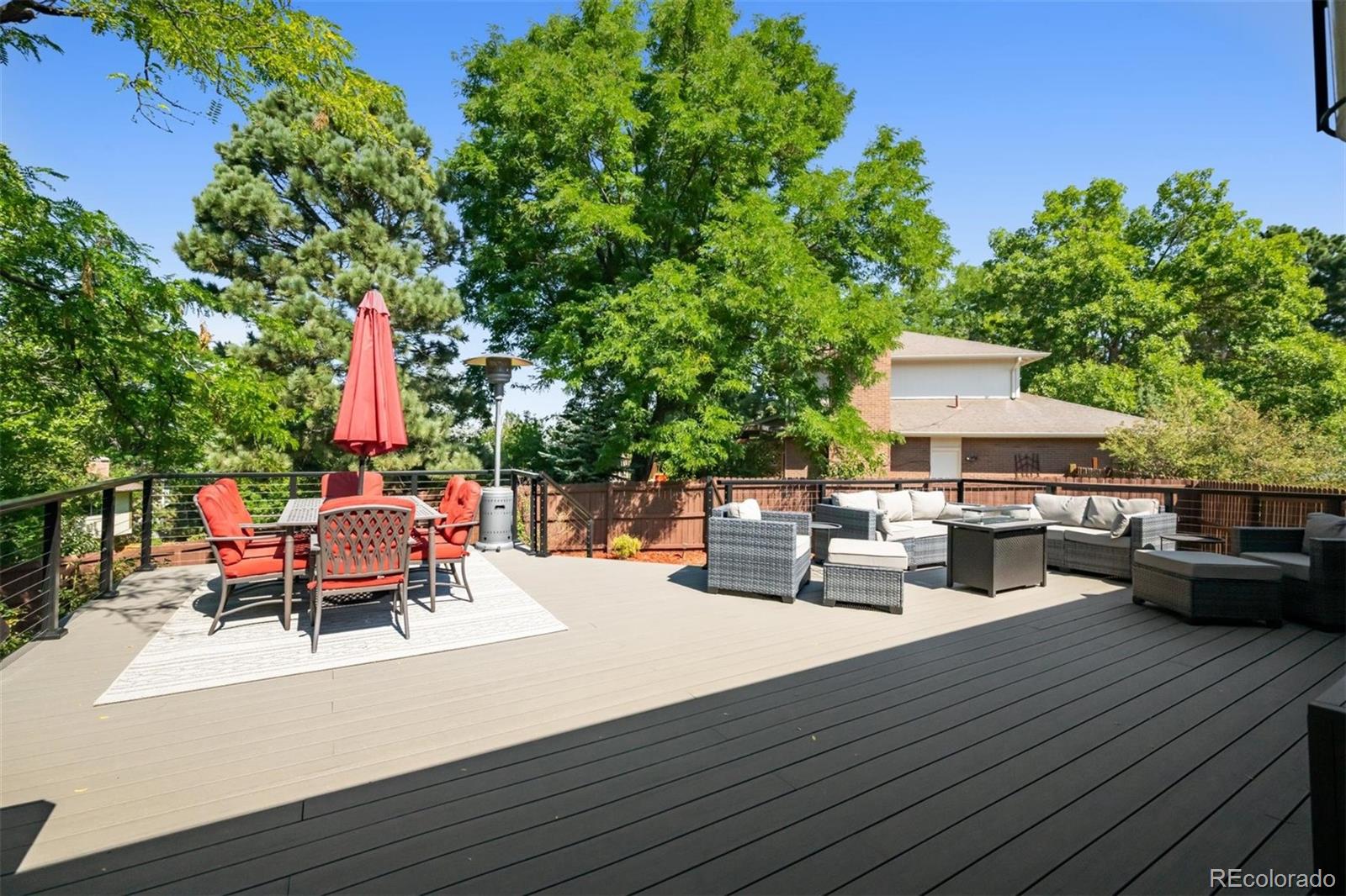 7659 South Fillmore Way Centennial, CO 80122 - Photo 32 of 45 a view of a roof deck with table and chairs with wooden floor and fence