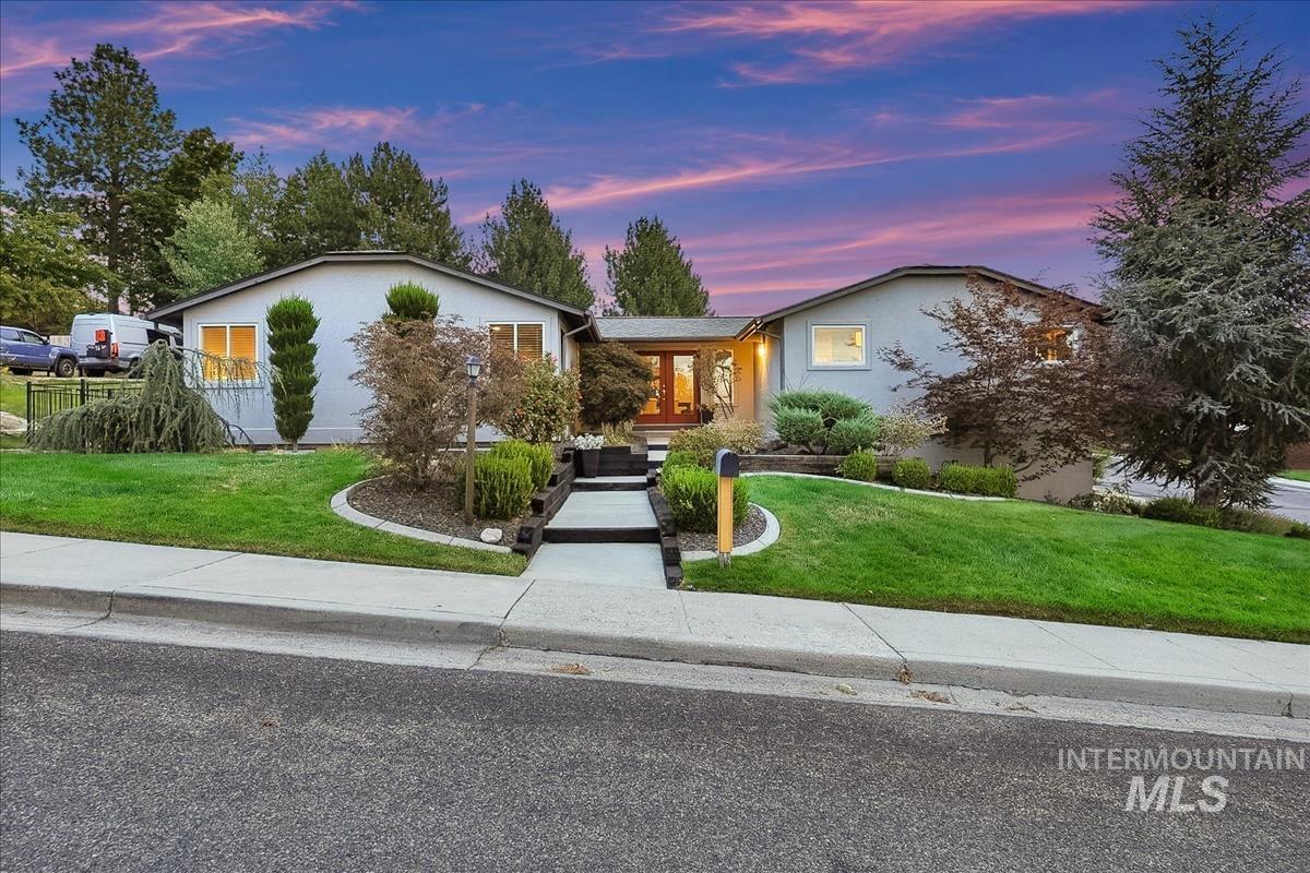 709 East Braemere Road Boise, ID 83702 - Photo 1 of 50 Stucco exterior with a pitched roofline, prominent front entry with double doors, and established landscaping with mature trees and shrubs
