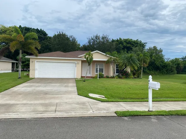 a front view of a house with a yard and trees