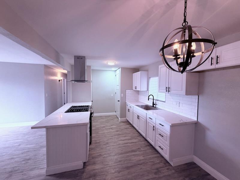 930 I Street Sanger, CA 93657 - Photo 8 of 15 a large room with kitchen island stainless steel appliances and wooden floor