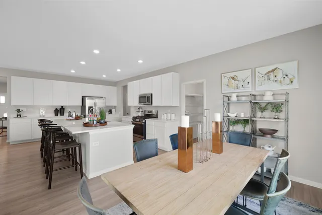 a kitchen with a dining table chairs and refrigerator