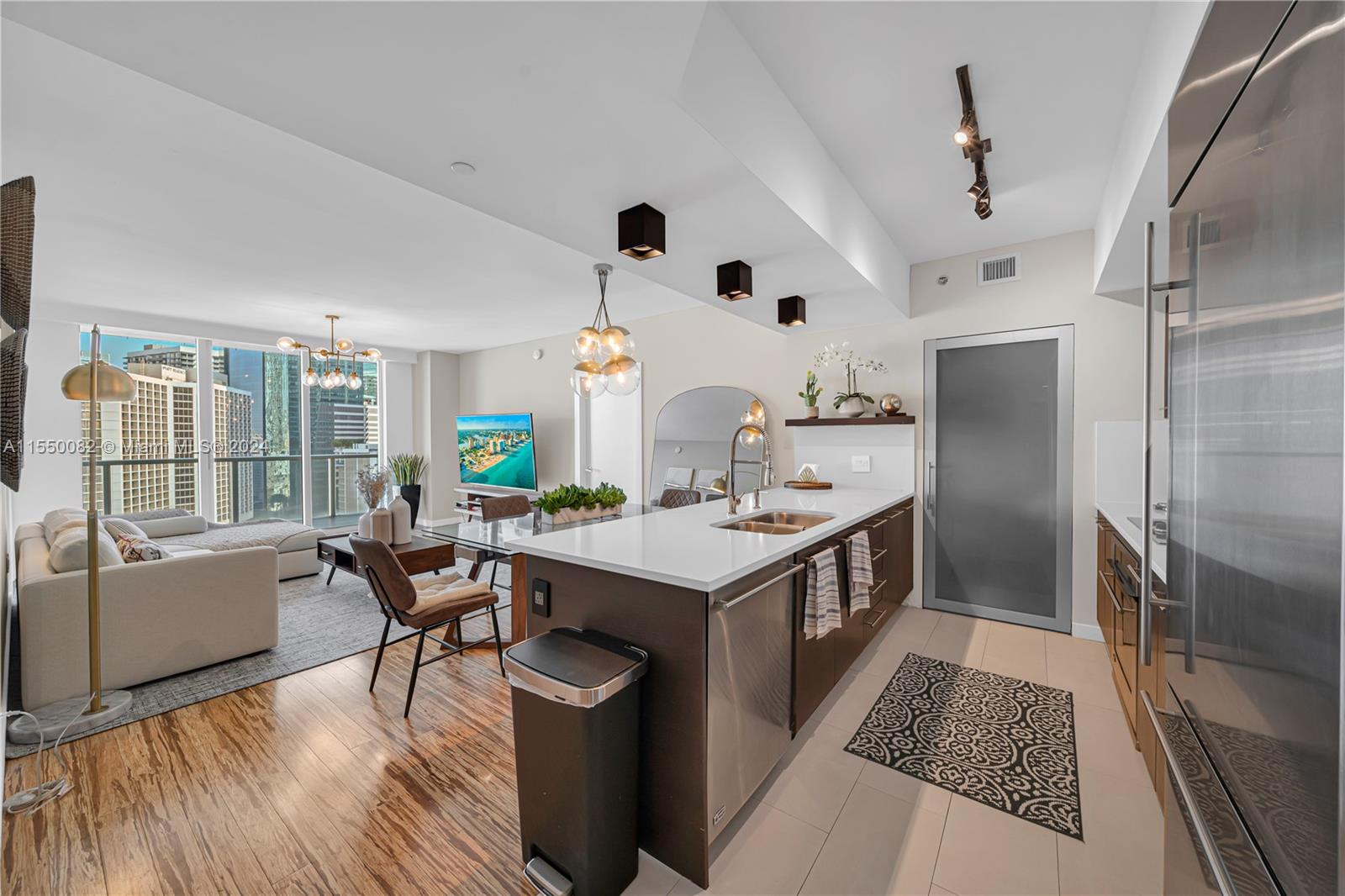 a kitchen with kitchen island a large counter top space a sink stainless steel appliances and cabinets