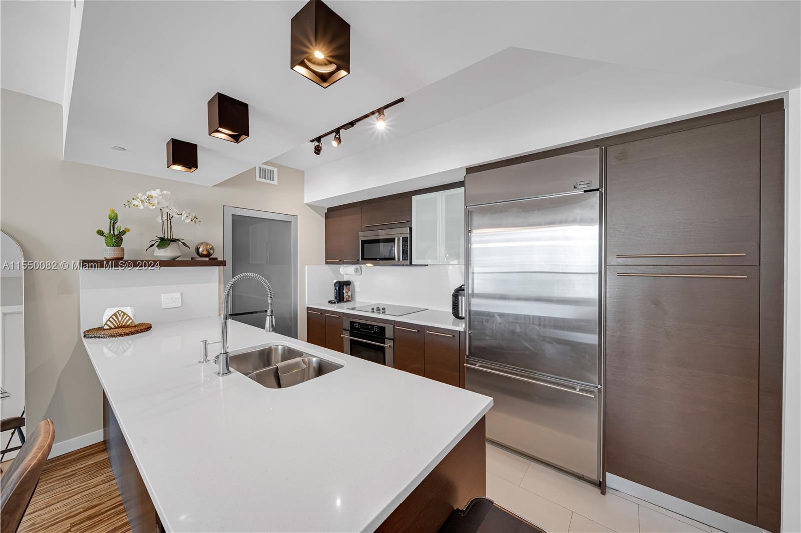Brickell Miami, FL 33131 - Photo 2 of 61 a kitchen with kitchen island a stove a sink and a refrigerator