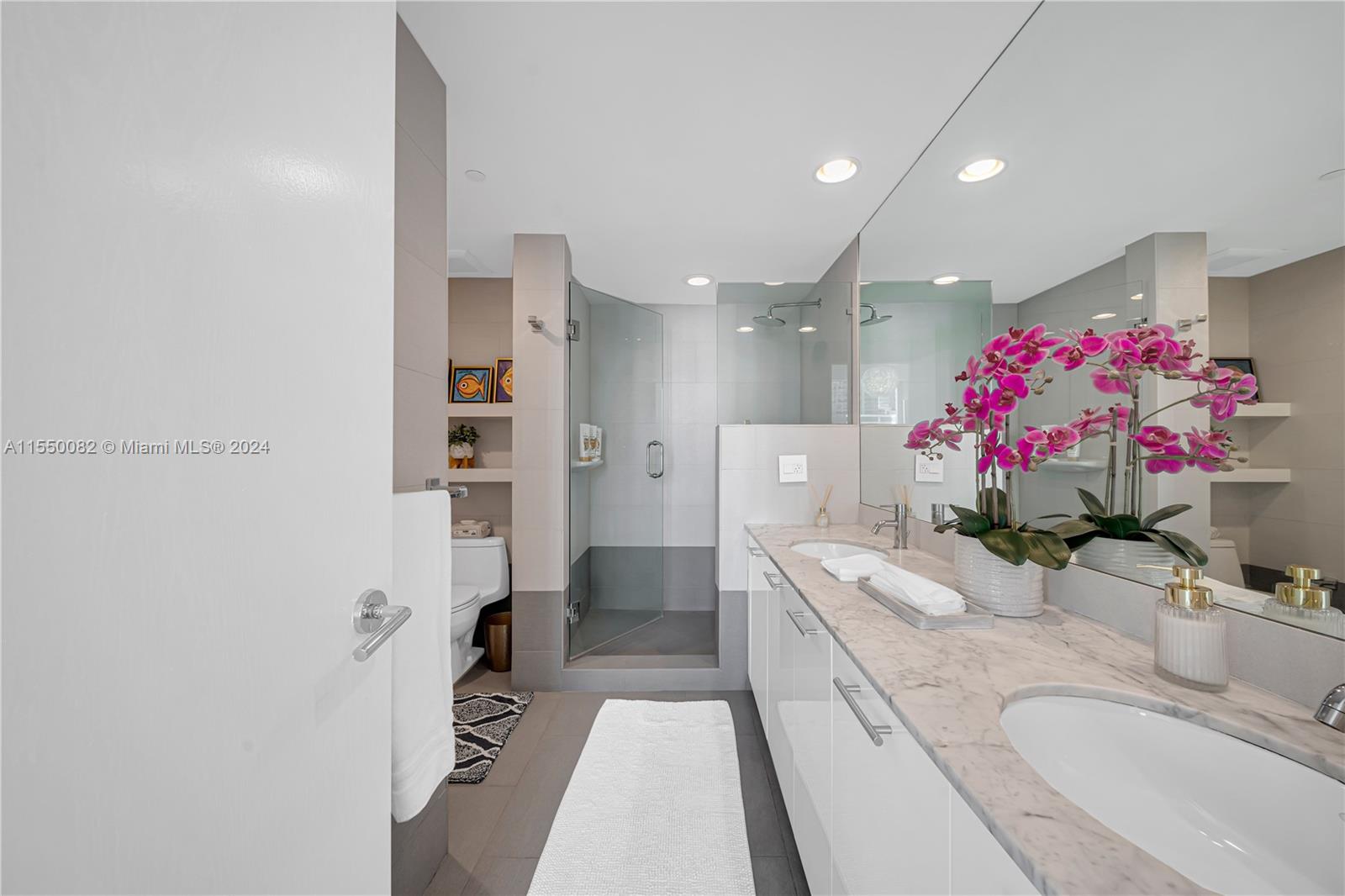 Brickell Miami, FL 33131 - Photo 25 of 61 a bathroom with a granite countertop shower a sink and a mirror