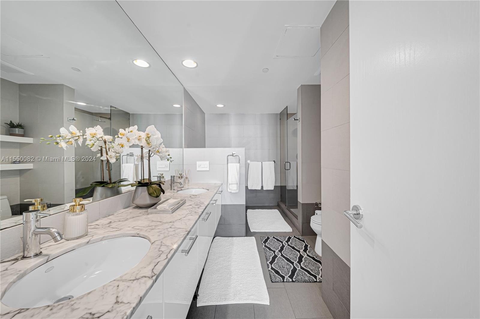 Brickell Miami, FL 33131 - Photo 34 of 61 a large white room with a large mirror and chandelier