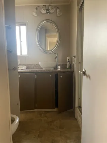 a bathroom with a granite countertop shower mirror and a sink