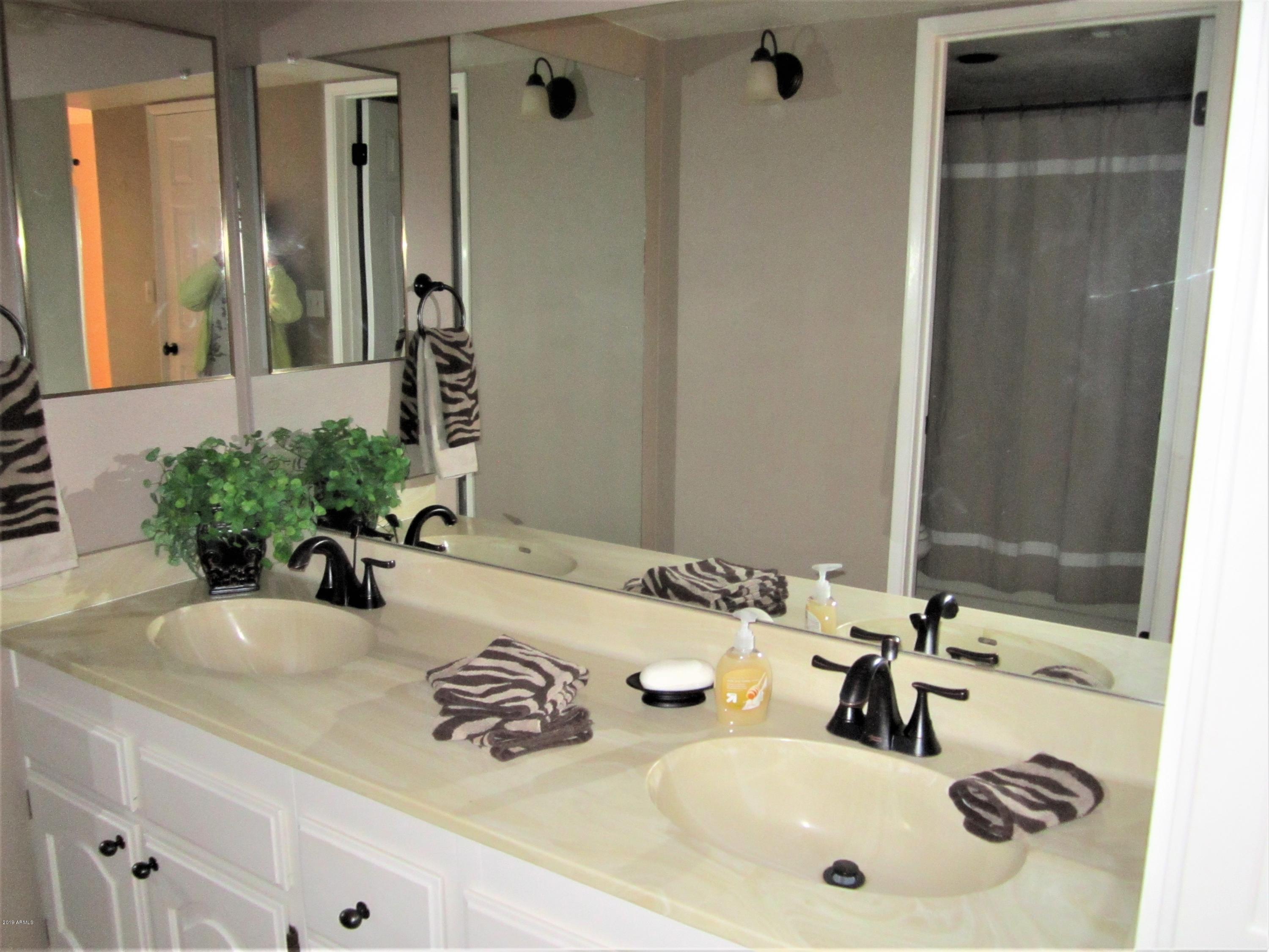 4303 East Cactus Road, Unit 116 Phoenix, AZ 85032 - Photo 20 of 35 a bathroom with a double vanity sink and a mirror