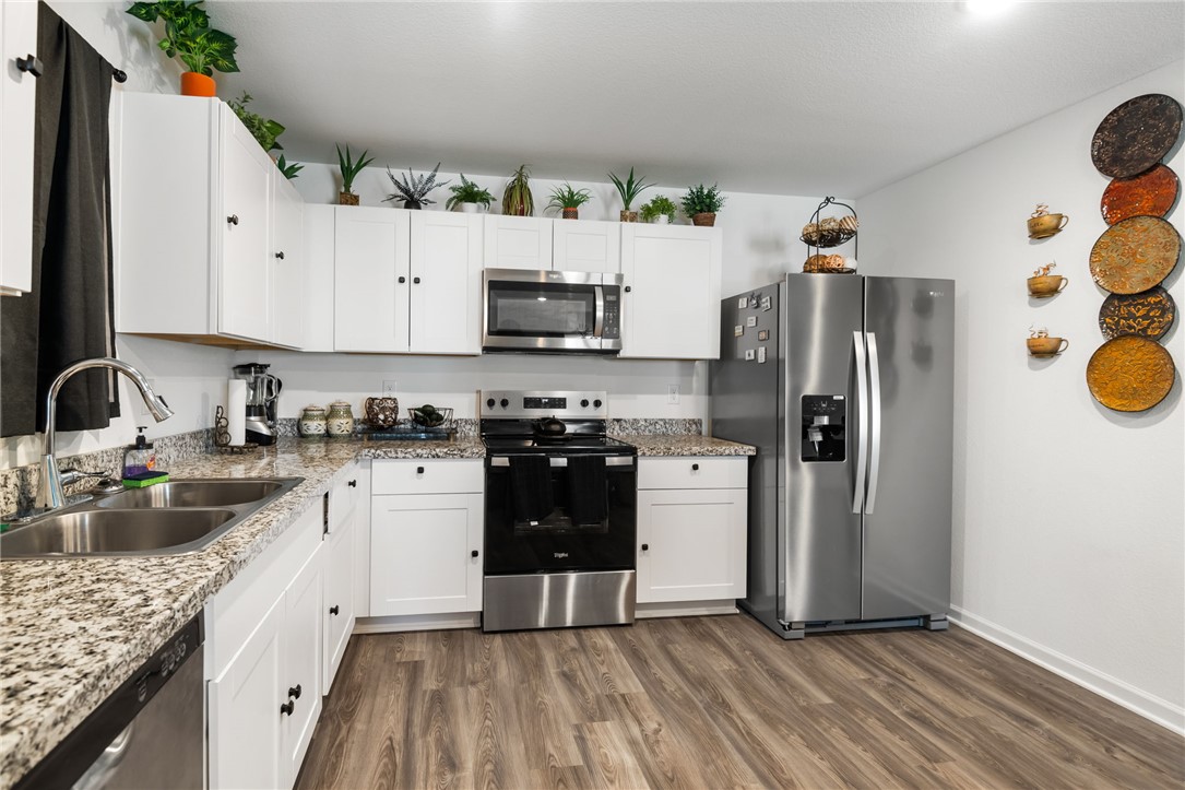 3623 East Andrea Drive Kingman, AZ 86409 - Photo 13 of 40 The kitchen features white cabinetry, granite countertops, and stainless steel appliances including a refrigerator, range, and built-in microwave