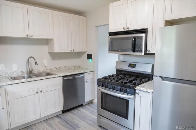a kitchen with white cabinets and appliances