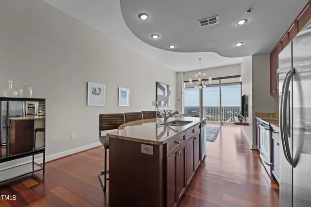 a kitchen with stainless steel appliances a sink a stove and a wooden floors