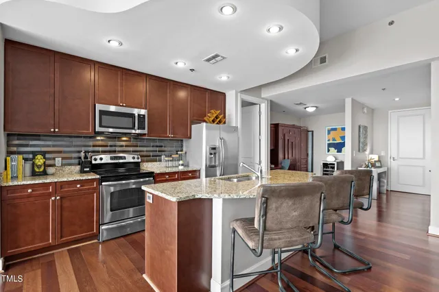a bedroom with a bed and a lamp on dresser