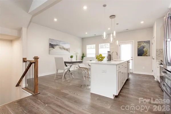 a large white kitchen with lots of counter space and stainless steel appliances