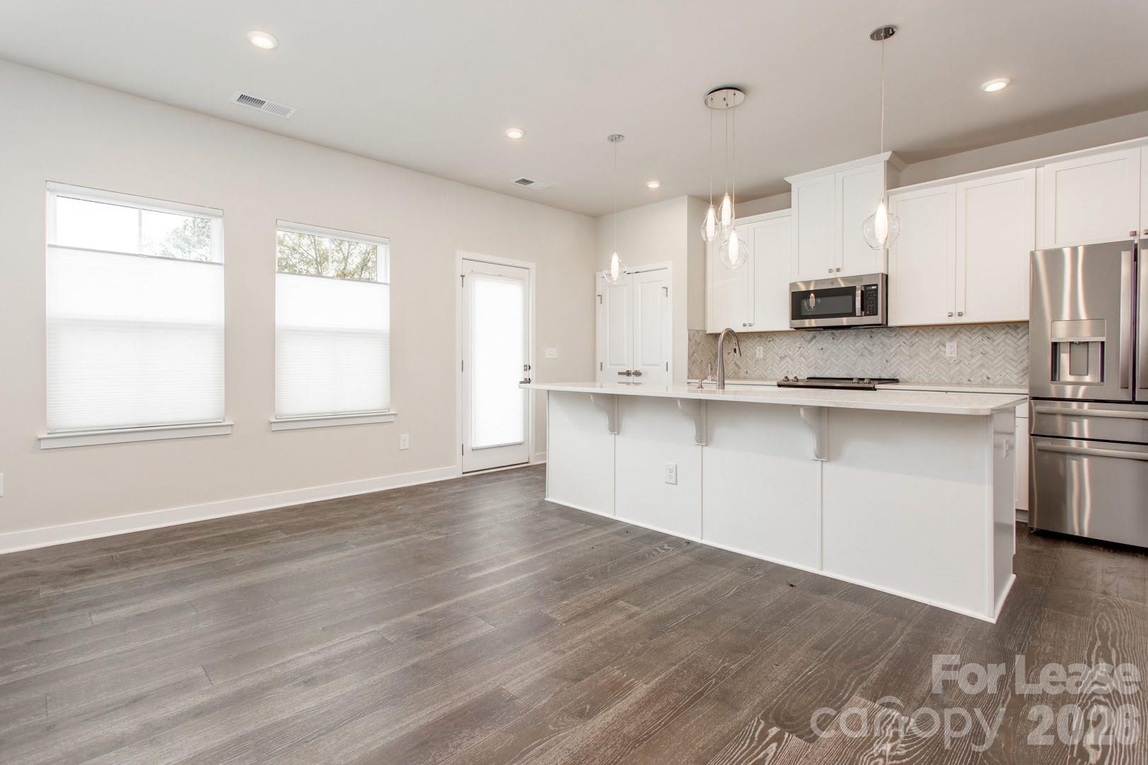 657 Uwharrie River Road Charlotte, NC 28211 - Photo 6 of 16 a kitchen with stainless steel appliances granite countertop a sink a stove a refrigerator and white cabinets