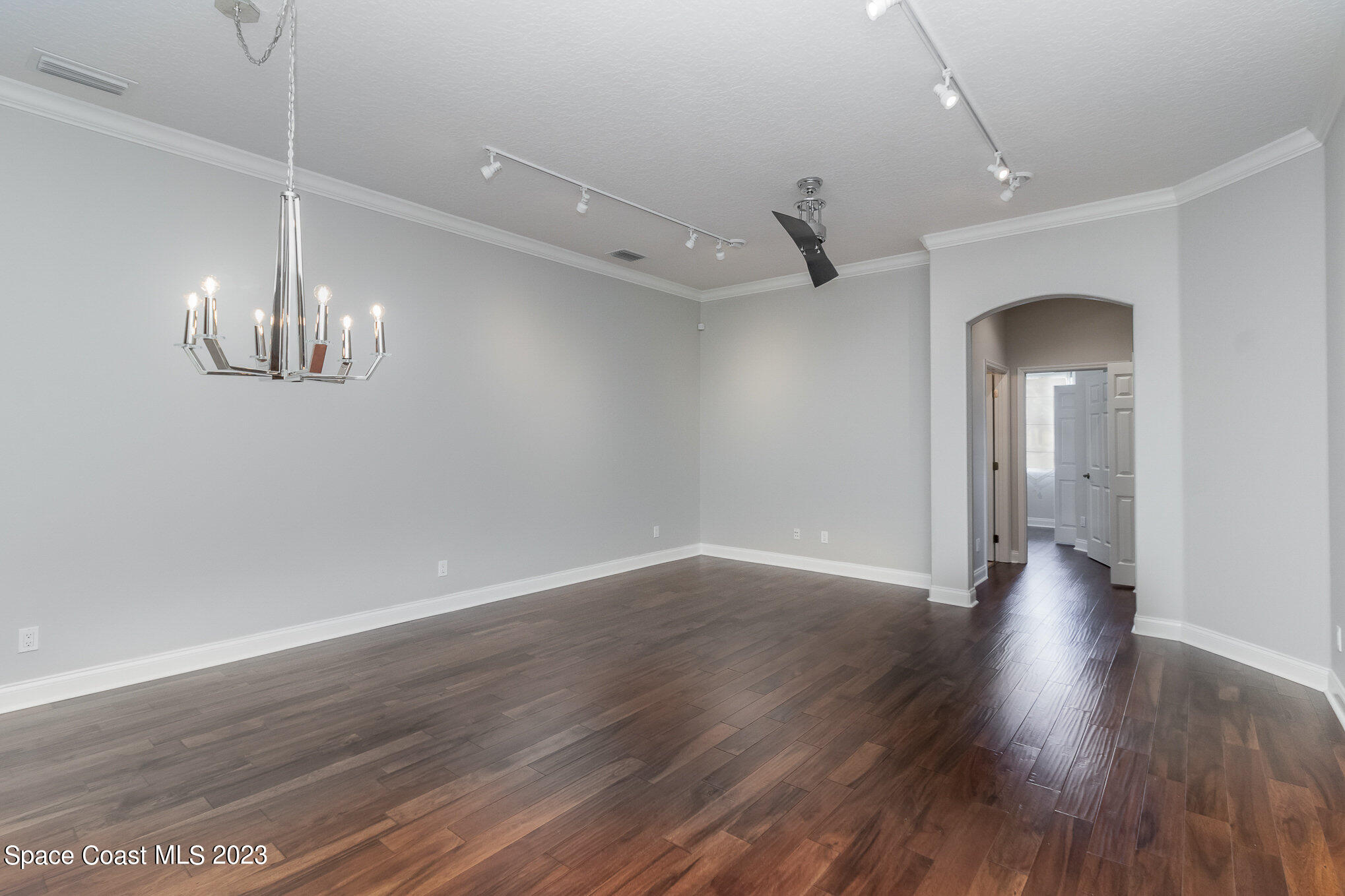 4250 Alamanda Key Drive Melbourne, FL 32901 - Photo 11 of 33 a view of an empty room with wooden floor and a ceiling fan