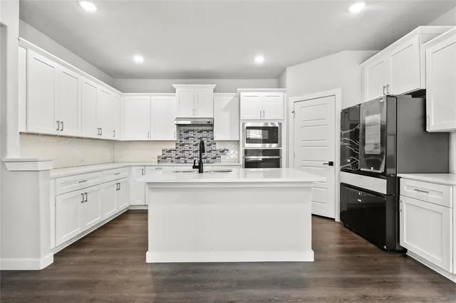 a kitchen with granite countertop white cabinets and white appliances