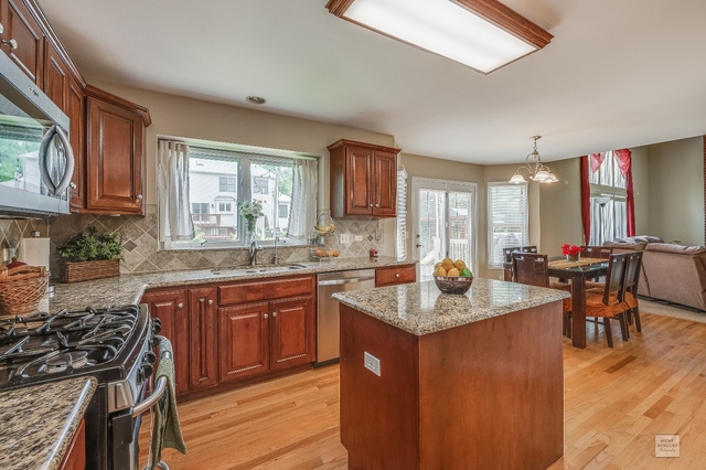 1805 Marne Road Bolingbrook, IL 60490 - Photo 8 of 27 a kitchen with granite countertop a sink stove and cabinets
