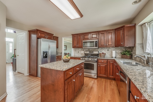 1805 Marne Road Bolingbrook, IL 60490 - Photo 9 of 27 a kitchen with stainless steel appliances granite countertop a stove a sink dishwasher a refrigerator and a oven with wooden floor