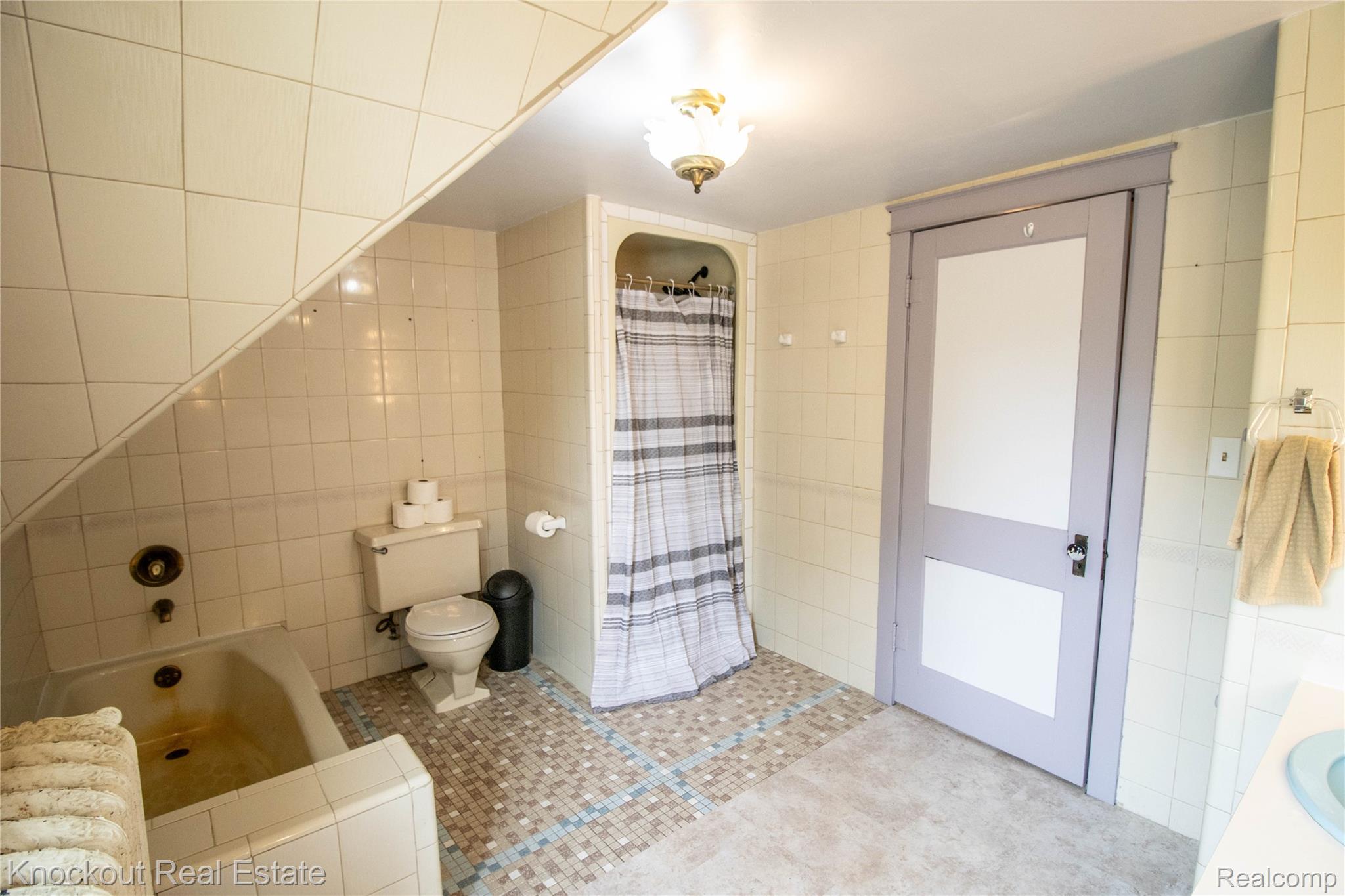 19983 West Ridge Road Henderson, MI 48841 - Photo 56 of 76 Bathroom featuring a built-in tub, tiled walls, mosaic floor accents, and a shower stall with a privacy curtain