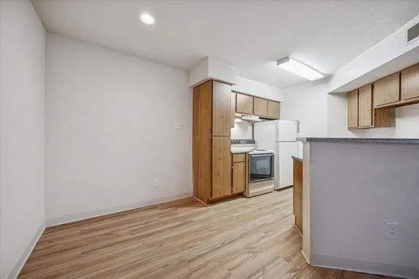 a kitchen with a refrigerator and a stove top oven