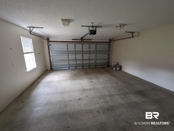 12971 Labradors Run Foley, AL 36535 - Photo 22 of 23 Spacious garage featuring a concrete floor, overhead lighting, an automatic garage door opener, and a single window for natural light