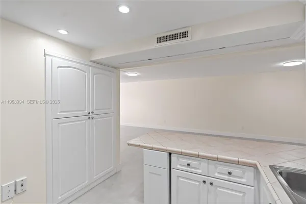 a view of a kitchen with white cabinets