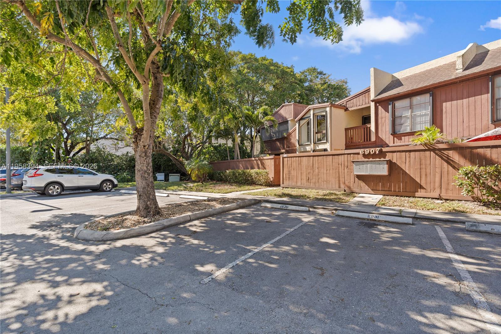 6907 Southwest 115th Place, Unit D40 Miami, FL 33173 - Photo 2 of 38 a front view of a house with a yard and parking