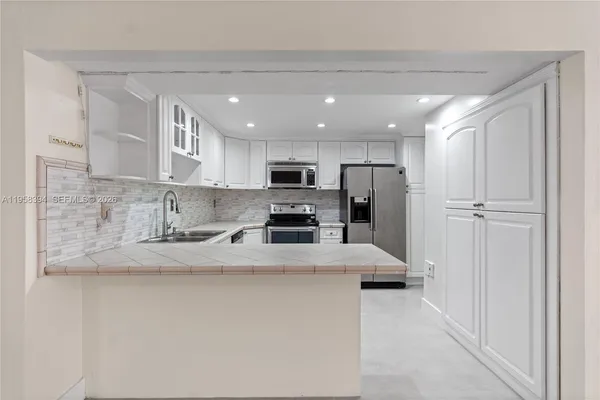 a kitchen with stainless steel appliances granite countertop a refrigerator sink and cabinets