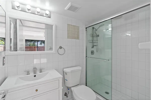a bathroom with a toilet sink vanity and shower