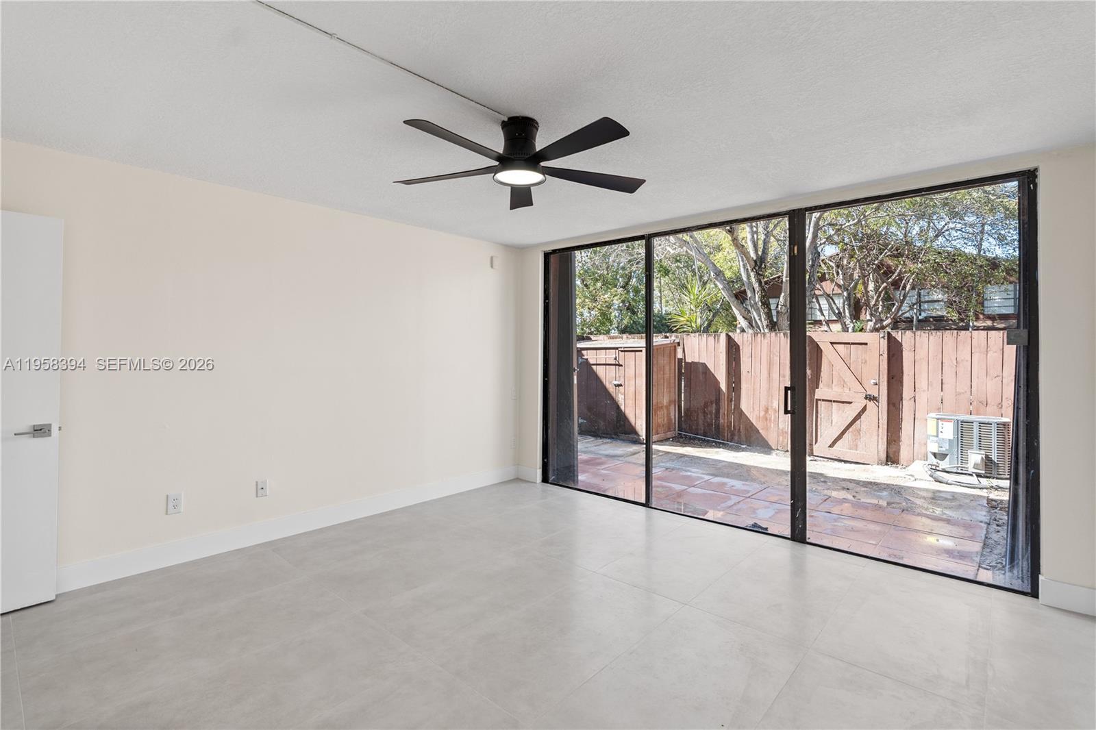 6907 Southwest 115th Place, Unit D40 Miami, FL 33173 - Photo 6 of 38 a view of an empty room and floor to ceiling window