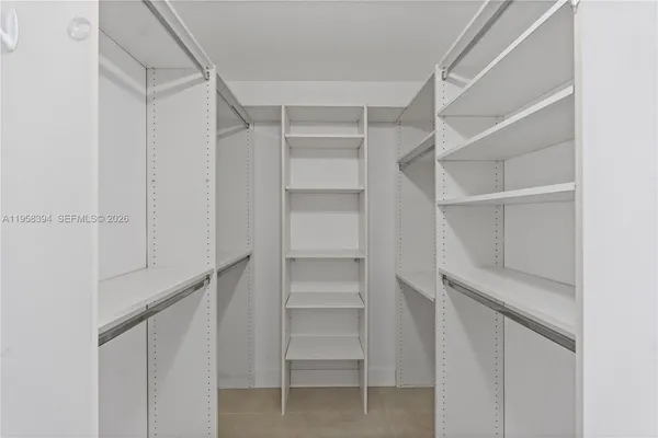 a view of walk in closet with empty racks