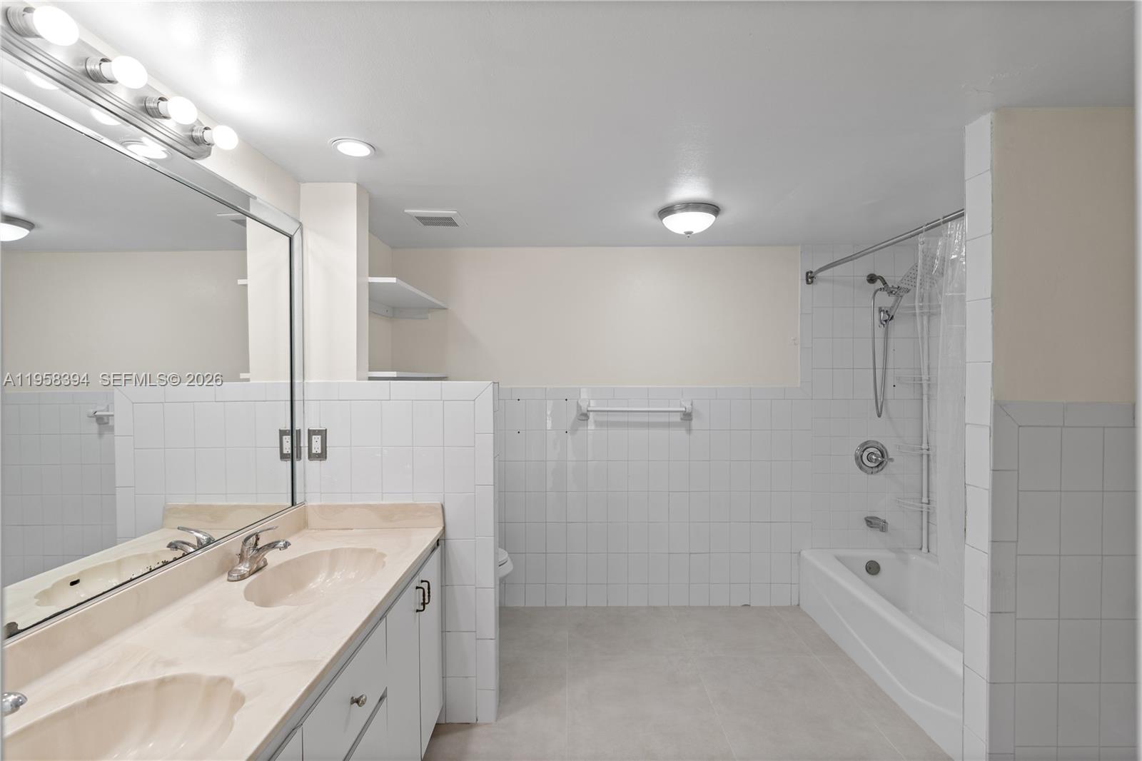 6907 Southwest 115th Place, Unit D40 Miami, FL 33173 - Photo 9 of 38 a bathroom with a granite countertop sink a shower and a mirror