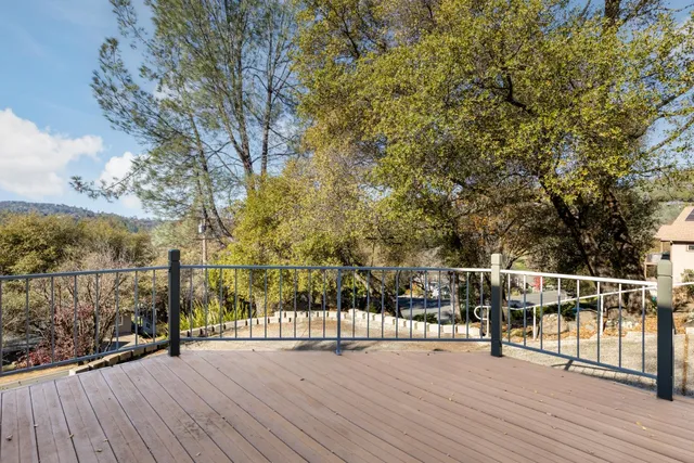 a view of a balcony with wooden floor and fence