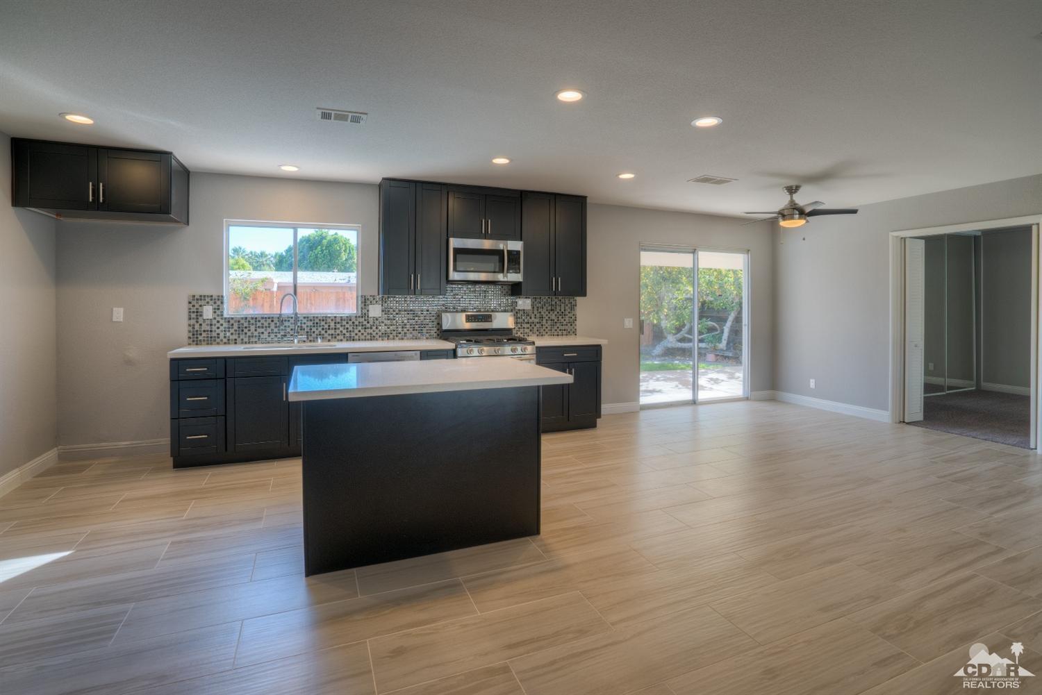 70121 Cobb Road Rancho Mirage, CA 92270 - Photo 4 of 15 a kitchen with kitchen island a sink appliances and cabinets