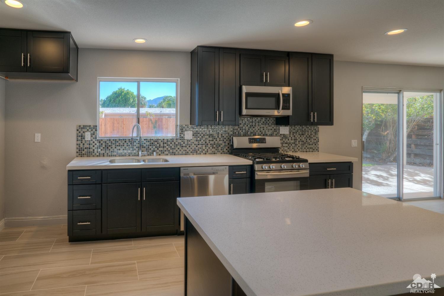 70121 Cobb Road Rancho Mirage, CA 92270 - Photo 5 of 15 a kitchen with stainless steel appliances a stove sink microwave and refrigerator